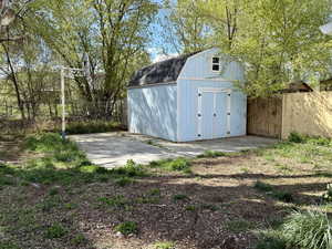 View of shed featuring fence