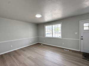Entrance foyer featuring ornamental molding, wood finished floors, and visible vents