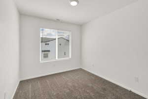 Spare room with carpet, visible vents, and baseboards