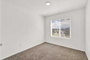 Unfurnished room featuring carpet floors, visible vents, and baseboards