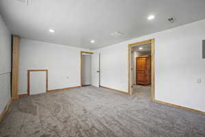 Lower level family room with built-in bookshelf, electric fireplace and brand new carpet.