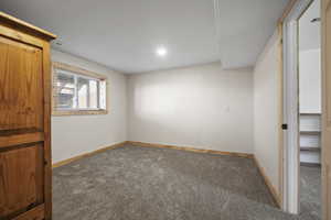 Large lower level bedroom with wood trim and brand new carpet.