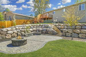 Amazing terraced  yard with paver patio, full fencing and boulder retaining walls.