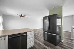 Updated kitchen with wood look flooring, white cabinets, and black stainless steel appliances.