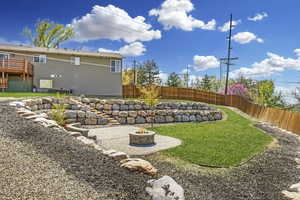 Amazing terraced  yard with paver patio, full fencing and boulder retaining walls.