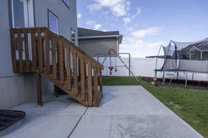 View of patio with stairway, fence, and a trampoline