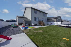 Rear view of house featuring a fenced backyard, a storage shed, an outdoor structure, a patio, and a trampoline