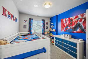 Bedroom featuring a textured ceiling, visible vents, and carpet