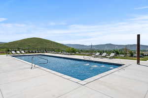 Pool featuring fence, a patio area, and a mountain view