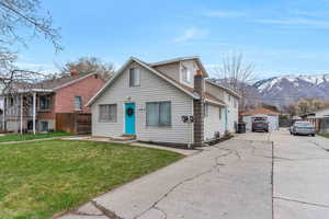 Bungalow featuring a mountain view, fence, concrete driveway, a garage, and a front yard