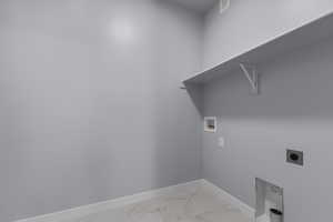 Washroom with marble finish floor, laundry area, hookup for a washing machine, baseboards, and electric dryer hookup
