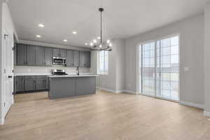 Kitchen featuring baseboards, an inviting chandelier, appliances with stainless steel finishes, and gray cabinets