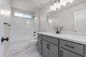 Full bathroom featuring toilet, vanity, and shower / washtub combination