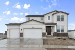 View of front of house with concrete driveway, fence, a garage, brick siding, and stucco siding