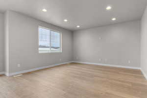 Spare room featuring light wood finished floors, baseboards, visible vents, and recessed lighting