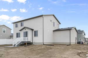 Rear view of property with fence and stucco siding
