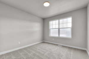 Empty room with baseboards, visible vents, and carpet