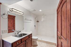 Bathroom featuring recessed lighting, visible vents, toilet, vanity, and a stall shower