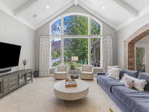 Living room with light colored carpet, recessed lighting, high vaulted ceiling, and beamed ceiling