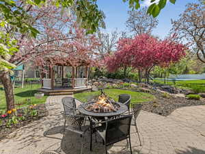 View of patio / terrace featuring fence, a gazebo, a playground, and an outdoor fire pit