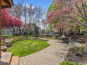 Surrounding community featuring a lawn, a fire pit, a patio area, and a wooden deck