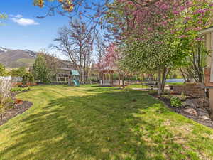 View of yard featuring fence, a gazebo, a mountain view, and a playground