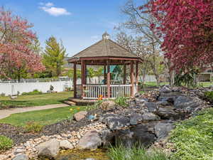 View of home's community with fence, a gazebo, and a lawn
