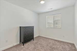 Unfurnished room featuring visible vents, carpet flooring, and baseboards