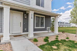 Entrance to property with a porch and a yard