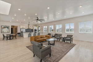 Living room with recessed lighting, light wood-style floors, and baseboards