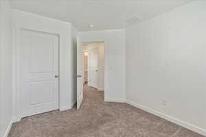 Unfurnished bedroom featuring light carpet, visible vents, and baseboards