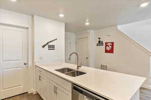 Kitchen featuring stainless steel dishwasher, a sink, light wood-type flooring, visible vents, and recessed lighting