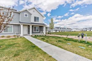 View of front of home featuring a porch, a residential view, and a front yard