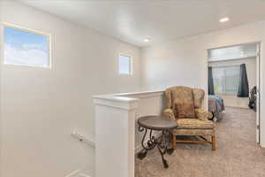 Sitting room featuring baseboards, carpet flooring, recessed lighting, and an upstairs landing