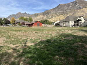 View of yard featuring an outdoor structure, fence, an outbuilding, and a mountain view