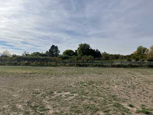 View of yard with a rural view and fence