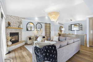 Living area with vaulted ceiling, wood finished floors, and a fireplace