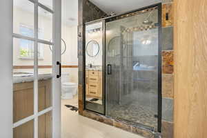 Bathroom with tile patterned flooring, vanity, toilet, and a stall shower