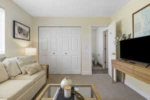 Carpeted living area featuring baseboards