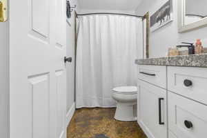 Full bathroom with vanity, a shower with shower curtain, and toilet