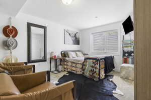 Bedroom featuring a textured ceiling, baseboards, and light carpet