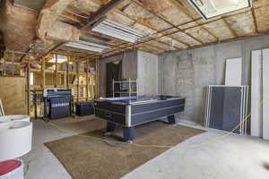 Game room with unfinished concrete flooring