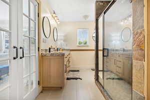 Full bathroom featuring plenty of natural light, vanity, and french doors