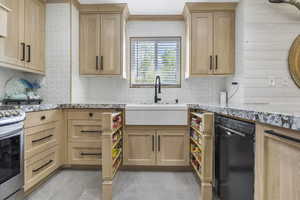 Kitchen featuring dishwasher, stainless steel gas range, light brown cabinetry, and a sink