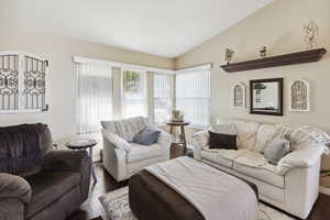 Living room with wood finished floors and lofted ceiling