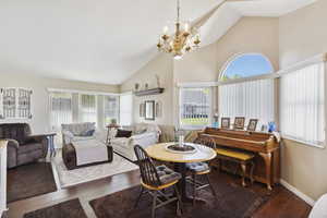 Dining space with an inviting chandelier, plenty of natural light, and high vaulted ceiling