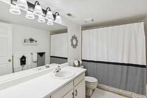 Bathroom with vanity, toilet, and visible vents