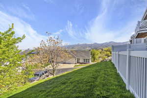 View of yard featuring fence and a mountain view