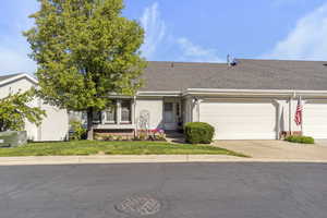 View of front of home featuring stucco siding, driveway, a shingled roof, and a garage
