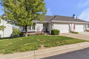 Single story home with a garage, a front lawn, concrete driveway, a shingled roof, and stucco siding